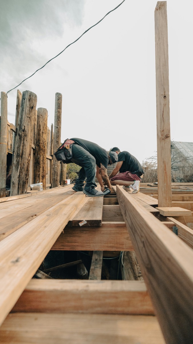 Builders fixing the timber frame of a new deck