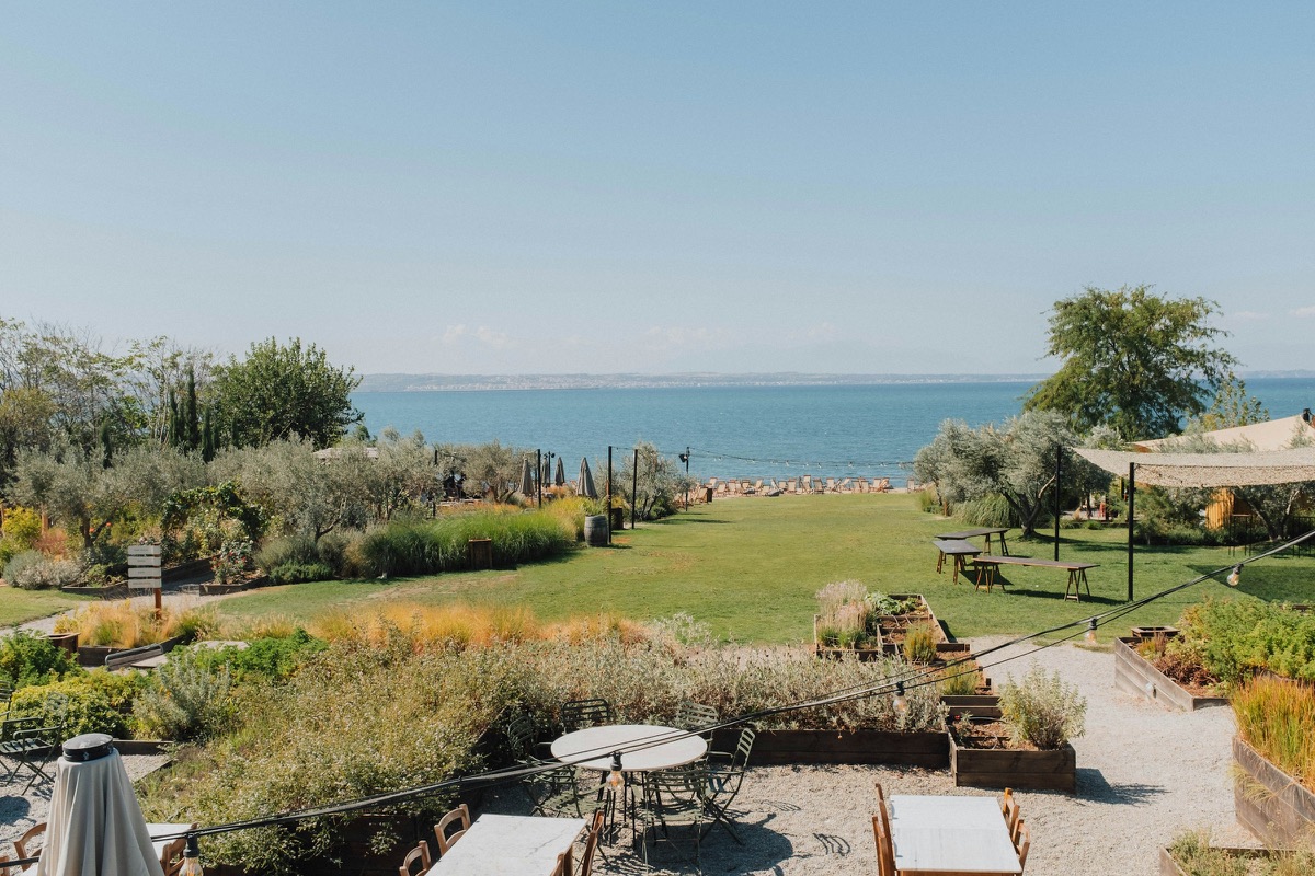 Landscaped garden sloping down to the ocean, with lawn, native planting and an outdoor seating area